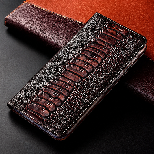 A closed dark brown reptile-pattern flip case lies on a two-tone leather-look book, showing a central row of large raised scales and finely pebbled sides.