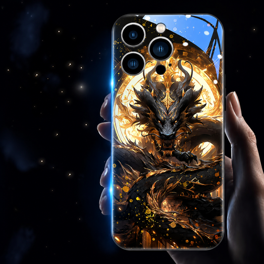 A hand holds a glossy black dragon phone case against a dark background sprinkled with gold specks. A black dragon coils in front of a luminous gold circle, with orange-gold fragments below. Blue light outlines one edge and a blue reflection crosses the top.