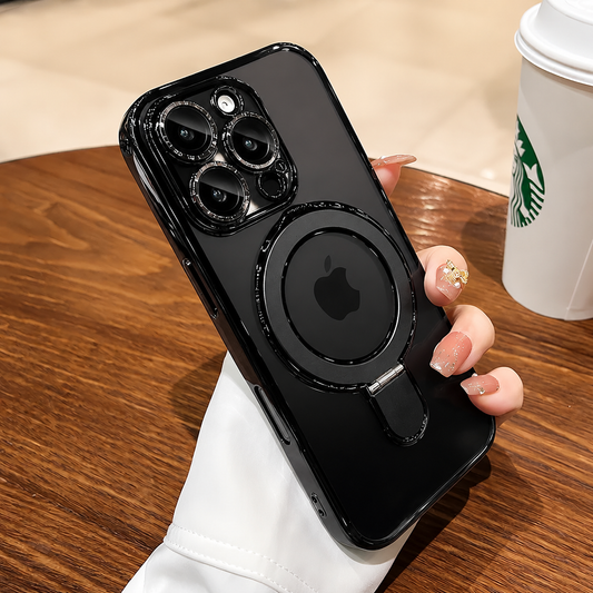 A hand holds a black clear-cased phone above a wooden cafe table beside a takeaway cup. The circular back ring lies folded flat.