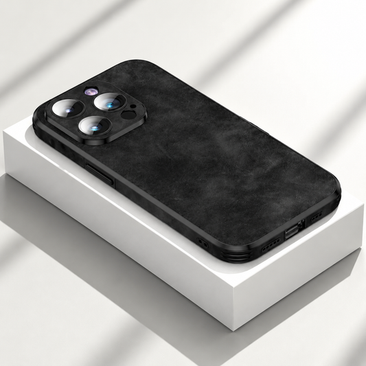 A black mottled case rests on a white box in angled sunlight, showing its textured rear finish and camera surround.