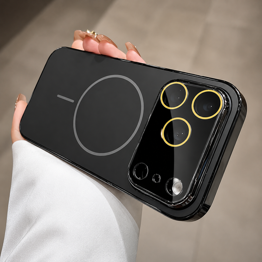 Hand holds a black case horizontally indoors, showing a gray magnetic circle and alignment bar beside a broad glossy camera panel with gold-colored lens rings.