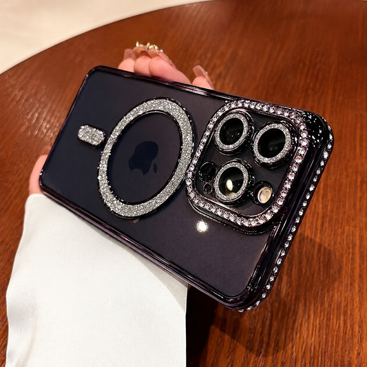 A hand in a white sleeve holds a dark purple-black phone case horizontally over wood. Silver glitter outlines the back ring and bar, with rhinestone-like studs around the cameras and edges.