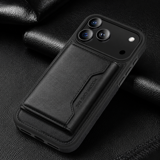 A black wallet case lies diagonally on textured black fabric, with a closed stitched flap below its broad camera panel.