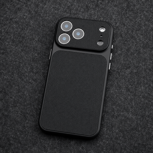 A black woven-texture phone case lies on dark gray fabric, showing its broad camera cover, individual lens openings and silver-colored side controls.