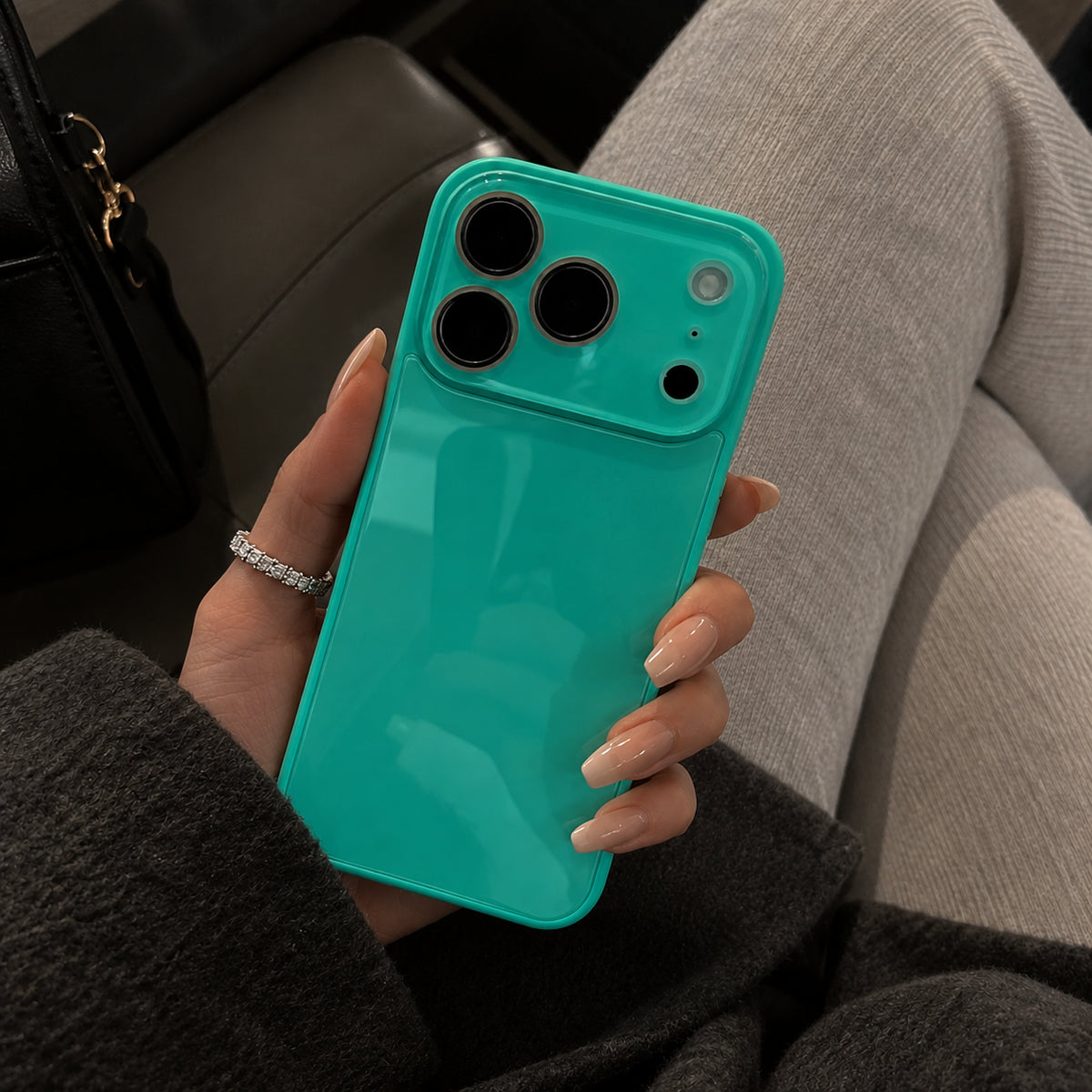 Image showing glossy Teal Phone in Hand, featuring iphone slim shockproof case with tempered glass back & camera protection.