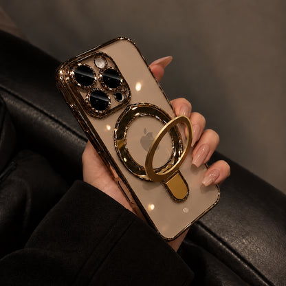 A hand with manicured nails holds a smartphone in a gold-toned case with a circular ring stand. The phone has a frosted beige back panel and a metallic gold camera surround, photographed against a dark leather seat.