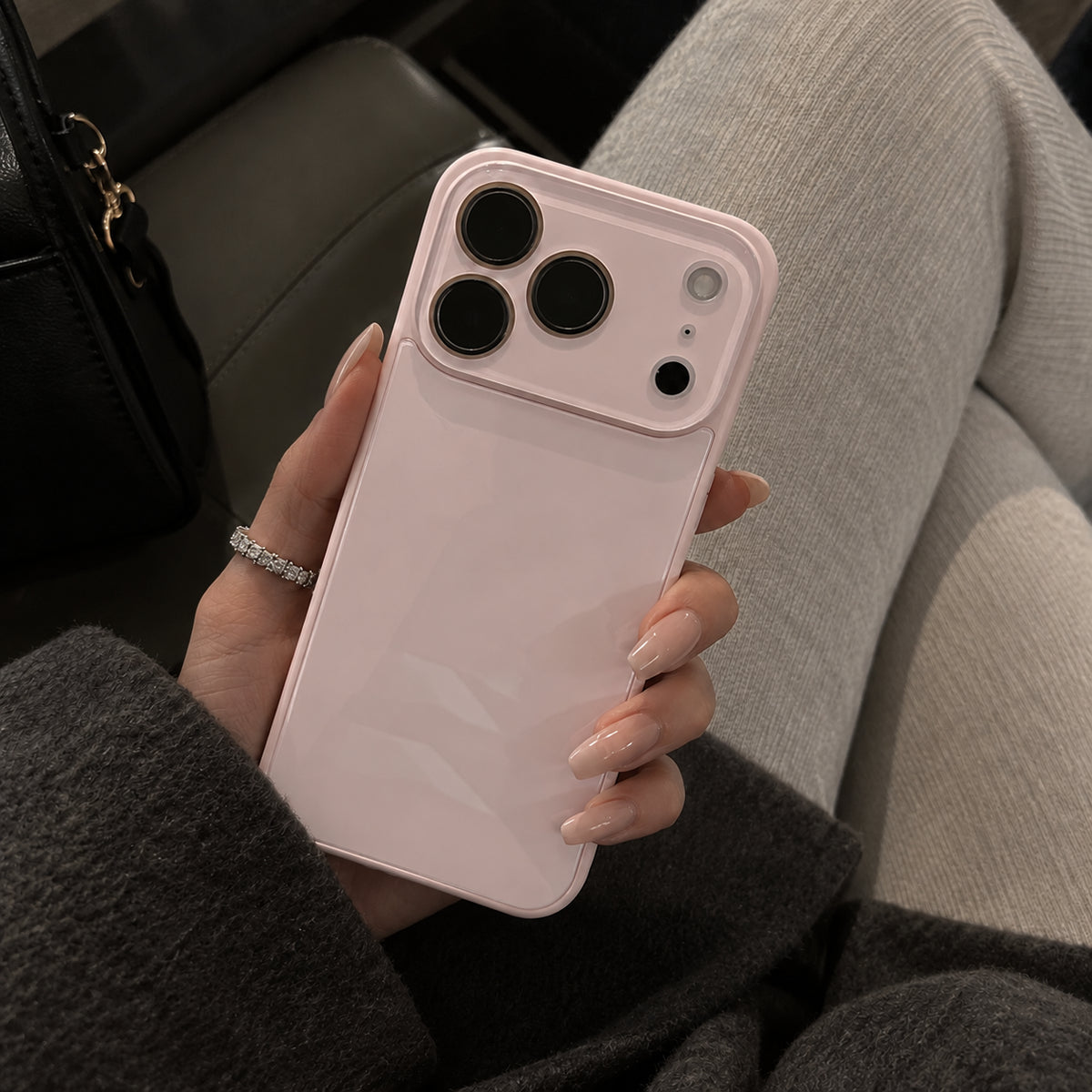 Image showing pale Pink Phone in Cosy Lounge Setting, featuring iphone slim shockproof case with tempered glass back & camera protection.