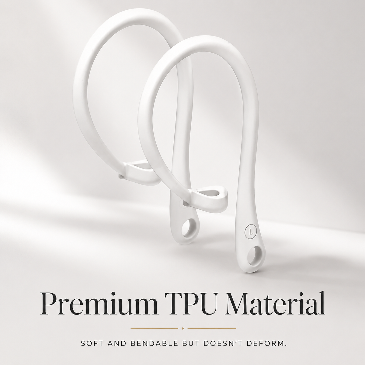 Two white ear hooks stand side by side with circular stem openings and left/right markings. Text advertises soft, bendable TPU material.