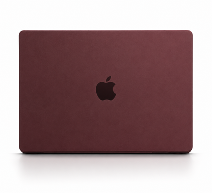 A closed MacBook is shown from behind in a matte burgundy fitted cover, with a dark Apple logo centered on the lid.