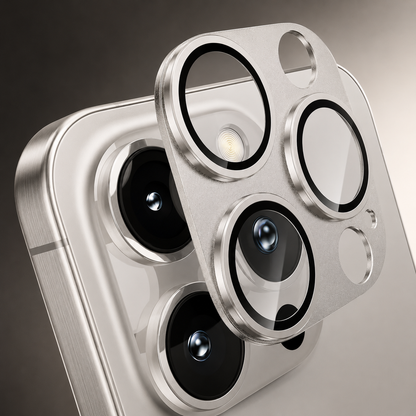 A silver-colored camera protector with three black-edged transparent lens rings floats close above a matching phone's camera cluster.