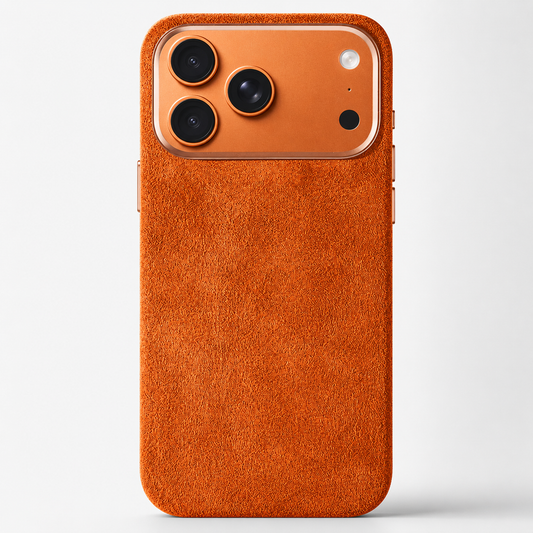 An orange case stands rear-facing against pale gray, with a fuzzy suede-like texture and matching broad camera surround.