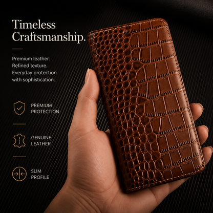 A hand holds a closed tan crocodile-pattern wallet upright against black. The glossy scale pattern and matching border stitching are shown closely. Text reads Timeless Craftsmanship.