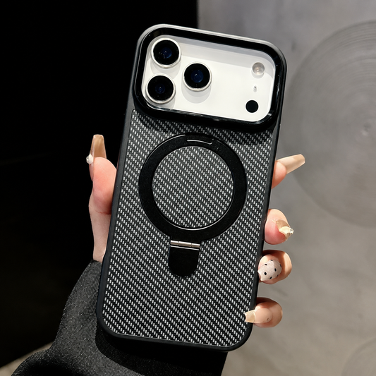 Hand holds a black-edged carbon-fiber-pattern case upright indoors, showing a large black circular ring stand folded flat beneath a broad raised camera opening.
