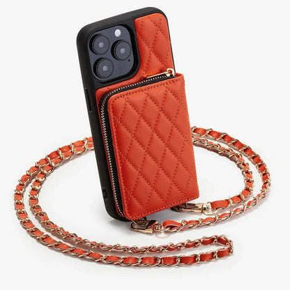 Orange quilted phone wallet case stands upright with a raised zippered pocket and black border. A gold-colored chain woven with orange material loops around the case.