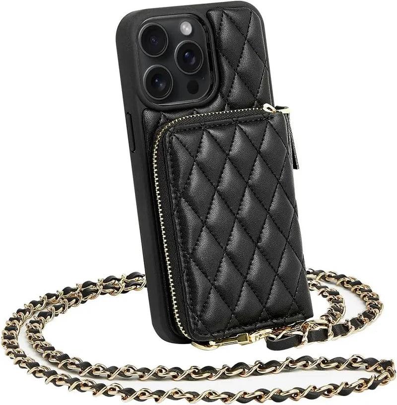 Black quilted phone wallet case stands upright with a raised zippered pocket on its back. A gold-colored chain woven with black material loops around it as a shoulder strap.