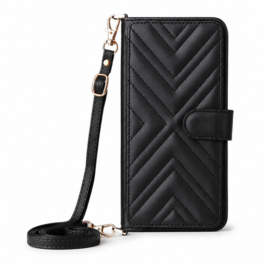 A closed black leather-look wallet phone case stands against white, with padded chevron stitching and a side closure tab. A matching adjustable strap attaches with gold-colored clips and lies looped beside it.
