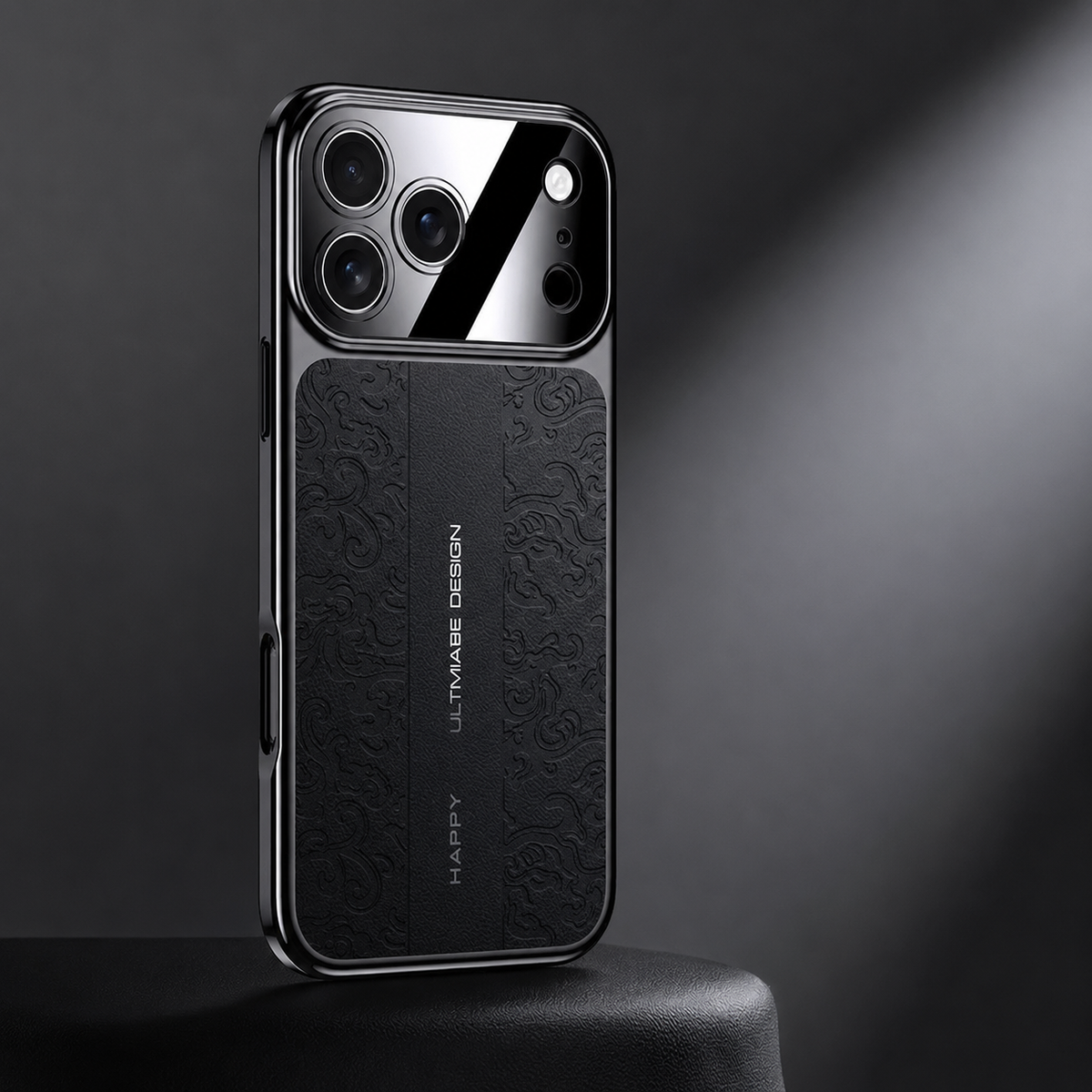A black embossed case stands on a dark pedestal in a diagonal beam of light. Its curling back pattern contrasts with the plain central strip and mirrored camera panel.