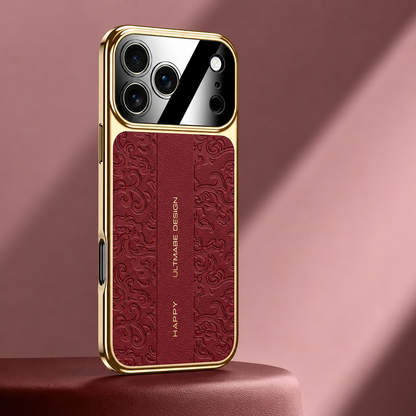 A burgundy embossed case stands on a red pedestal, bordered by gold-colored edges. Its curling motifs surround a plain central strip beneath the mirrored camera panel.
