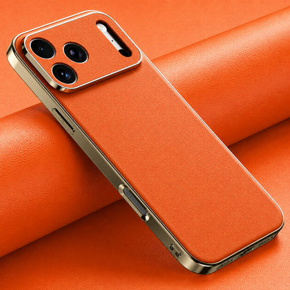 Orange finely textured case lies diagonally on orange material, with reflective gold-colored sides and matching camera panel around three lenses.