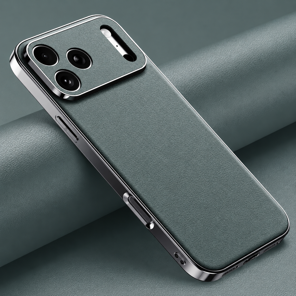 Muted green finely textured case lies diagonally on matching folded material, with reflective silver-colored edges and matching camera panel.