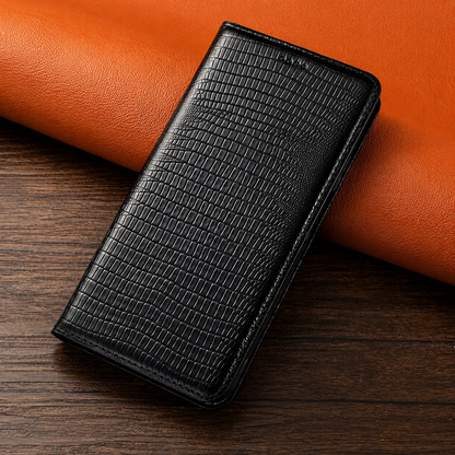 A closed black reptile-patterned folio case leans against orange material on a dark wooden table.