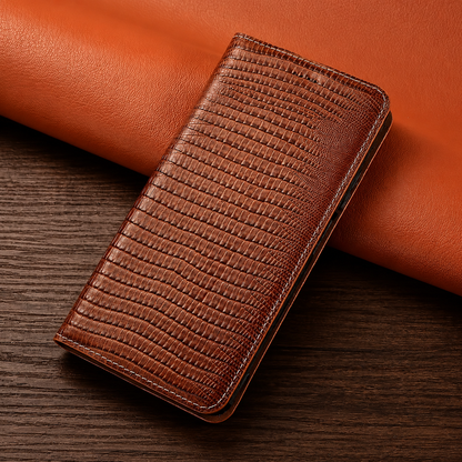 A closed brown reptile-patterned folio case leans against orange material on a dark wooden table.
