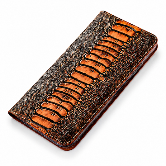 A closed brown-and-orange reptile-pattern flip phone case lies diagonally on white. A central row of large raised scales runs between finely pebbled side panels.