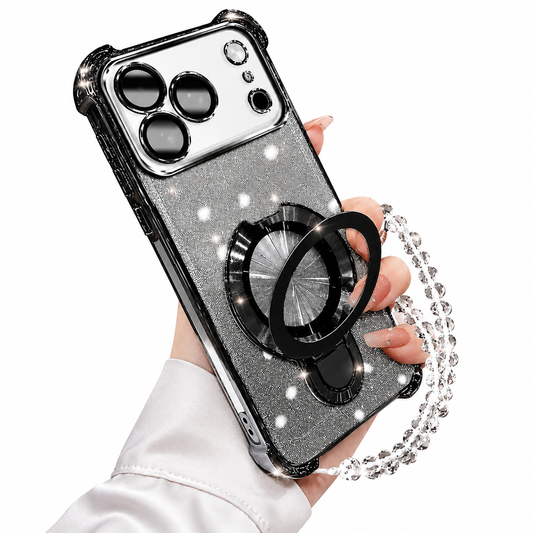 A hand holds a silver-glitter phone case with glossy black trim, a broad white camera panel and an opened circular black ring stand. A clear faceted-bead wrist loop hangs beside it.