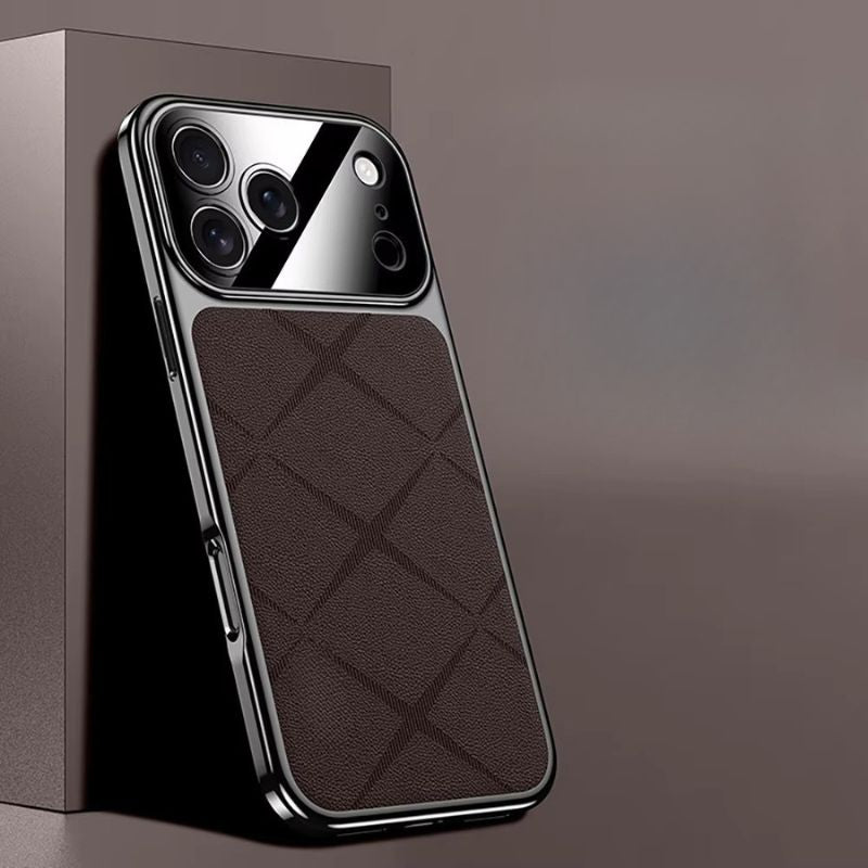 Brown diamond-pattern phone case leaning against a brown display block, with reflective dark edging and a glossy camera panel.