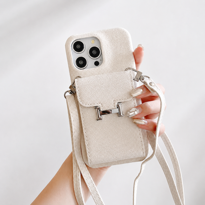 A hand holds a cream woven-textured case with a rear flap pocket, silver H-shaped clasp and matching cream straps.