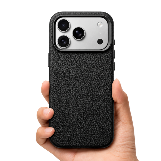 A hand holds a black phone case upright against white. Its back has a pronounced pebbled leather-look texture and a raised black frame around the broad three-camera opening.