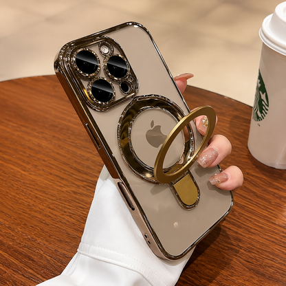 A hand holds a gold-edged clear-cased phone with its circular ring stand unfolded beside a takeaway cup on a wooden table.