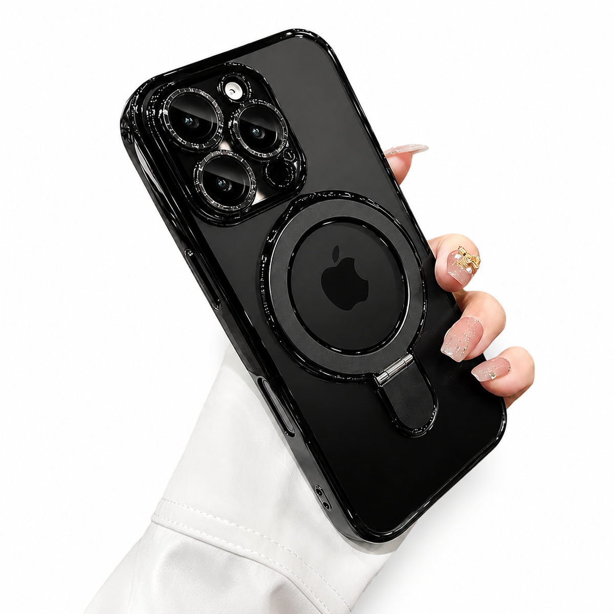 A hand holds a black-edged clear case on white, showing the phone's Apple logo inside a flat circular ring stand and raised glossy borders around the camera lenses.