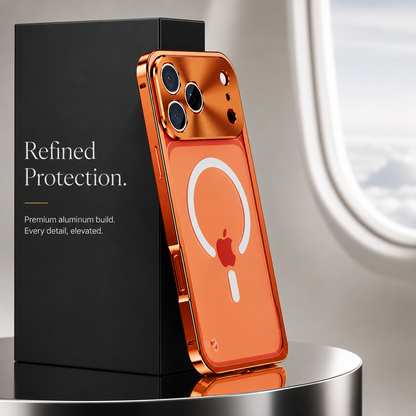 Orange-framed phone stands rear-forward against a dark block on a mirrored round table. Its frosted back has a white magnetic ring below a reflective camera panel.
