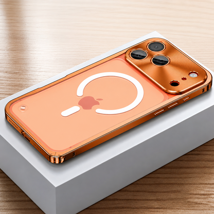 Orange framed case lies face down on a white box, showing a frosted transparent back with a white broken magnetic ring and alignment bar. A broad reflective camera panel surrounds three lenses.