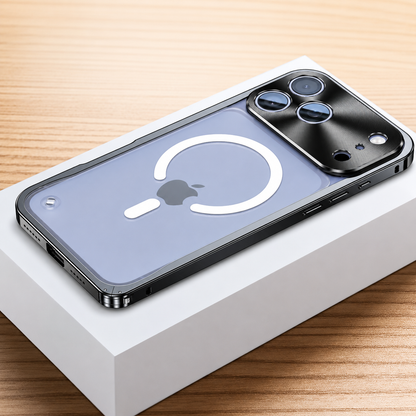 Black framed case lies face down on a white box, showing a frosted transparent back with a white broken magnetic ring and alignment bar. A broad reflective camera panel surrounds three lenses.