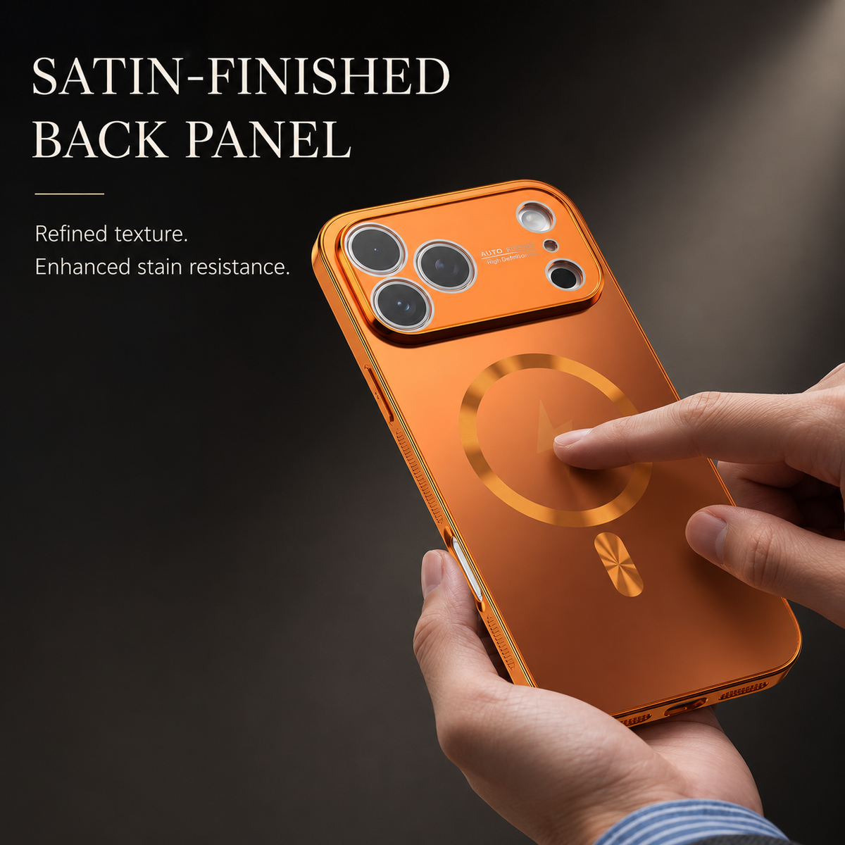 Hands hold an orange phone case while a finger touches its circular back marking. Text advertises a satin-finished back panel with enhanced stain resistance.