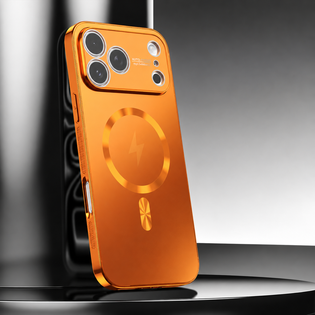 A bright orange metallic-looking phone case leans upright on a glossy black pedestal. A circular ring surrounds a lightning symbol on its back, beneath a broad orange camera panel.