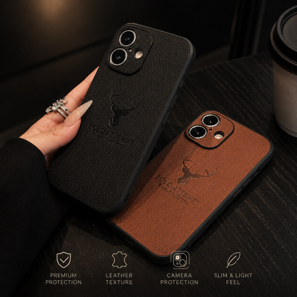 A hand holds a black case above a brown version resting on a dark table, both with textured backs and deer emblems.