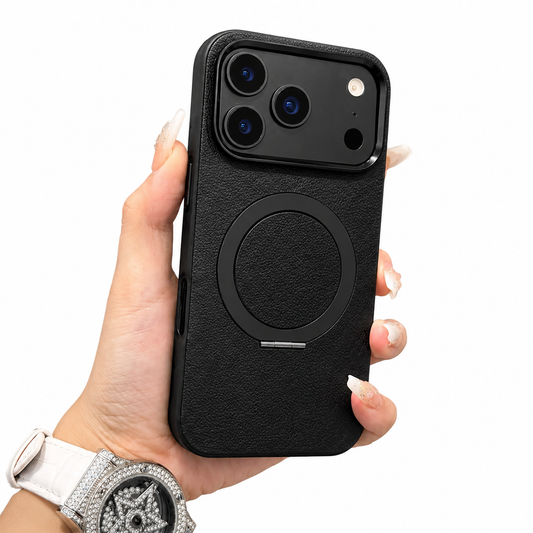 A hand wearing a large silver-colored watch holds a black textured case upright on white. A raised black camera panel and circular magnetic ring decorate the back.