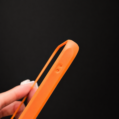 A hand bends the orange case edge slightly outward, showing its flexible-looking side and button covers.