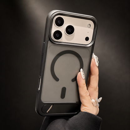 A hand holds a dark translucent case upright against black, showing its circular magnetic design and flat lower kickstand.