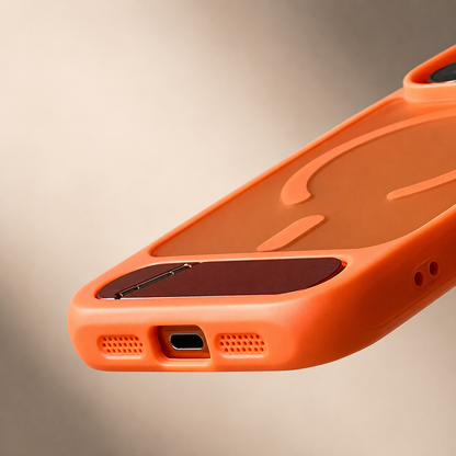 A close view of an empty orange case's bottom edge shows its charging-port and speaker cutouts, rounded corners and inset kickstand.