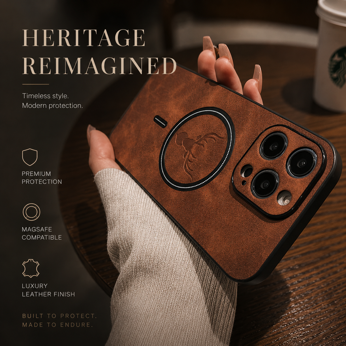 A hand in a cream knit sleeve holds a brown stag-emblem case diagonally above a wooden café table. Its mottled back has a dark circular ring around the deer head and a short alignment mark below. The heading reads Heritage Reimagined.