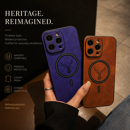 A hand fans blue-purple and orange-tan stag-emblem cases above a wooden café table. Dark magnetic rings encircle the embossed deer heads beneath the cameras. The heading reads Heritage. Reimagined, with labels advertising MagSafe compatibility, protection, leather finish and camera borders.