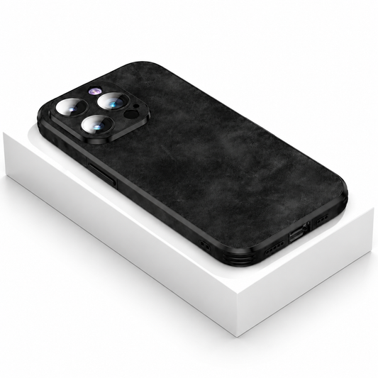 A black mottled-texture case lies rear-up on a white box, with a raised three-lens camera surround and black bumper edges.