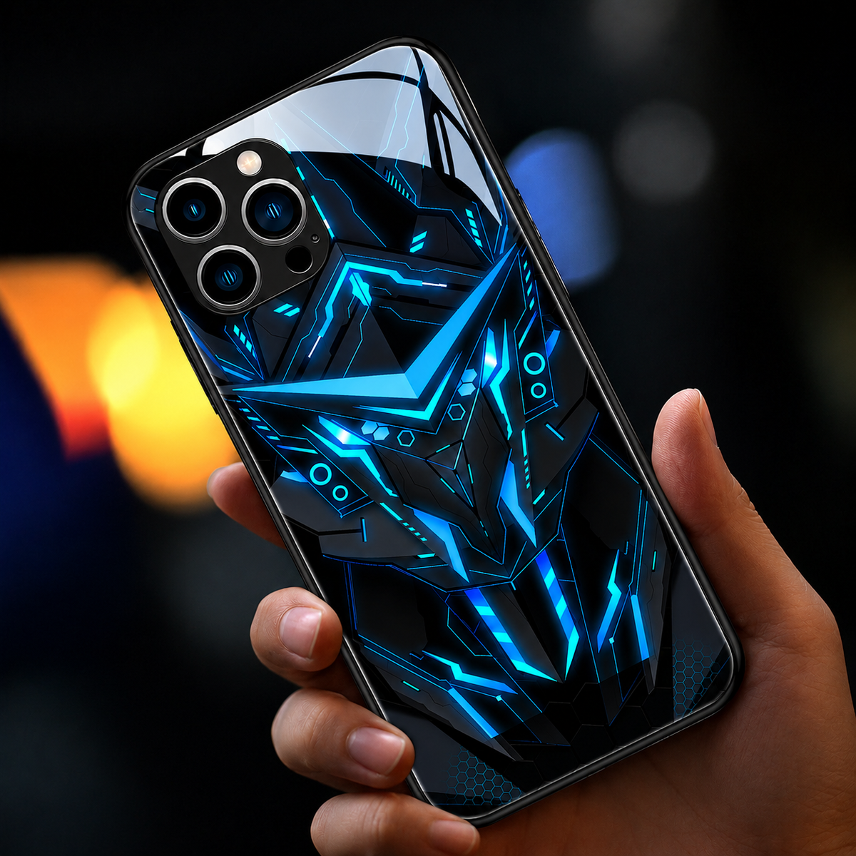 A hand holds a glossy black case with a blue angular robotic-face design against blurred colored lights.