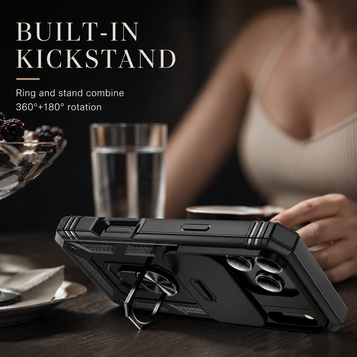 Black rugged case stands horizontally on its fold-out ring at a table with a glass of water and a person behind it. Text describes 360-degree plus 180-degree kickstand movement.