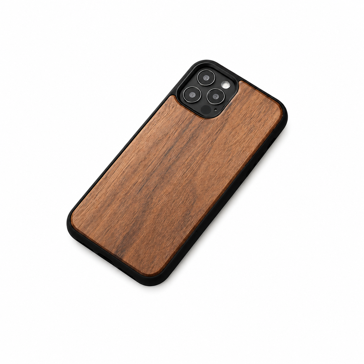 A phone lies diagonally on a plain white background with its wood-grain back facing upward. The warm brown panel has long darker streaks, a black border, and a rounded square opening around three rear camera lenses at the upper end. A soft shadow falls beneath its lower edge.