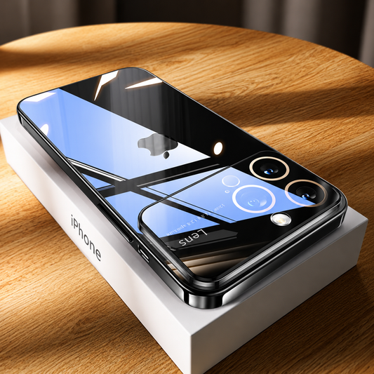 Dark glossy transparent phone case rests on a white iPhone box on a sunlit wooden table. Strong window reflections cross the back and broad camera panel.